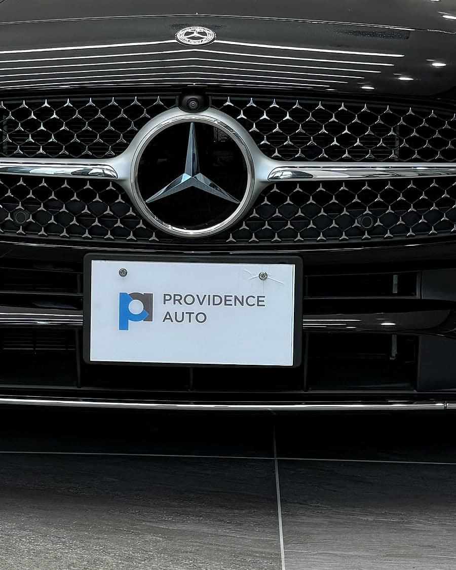 A Mercedes-Benz grille and star with a Providence Auto plate below it